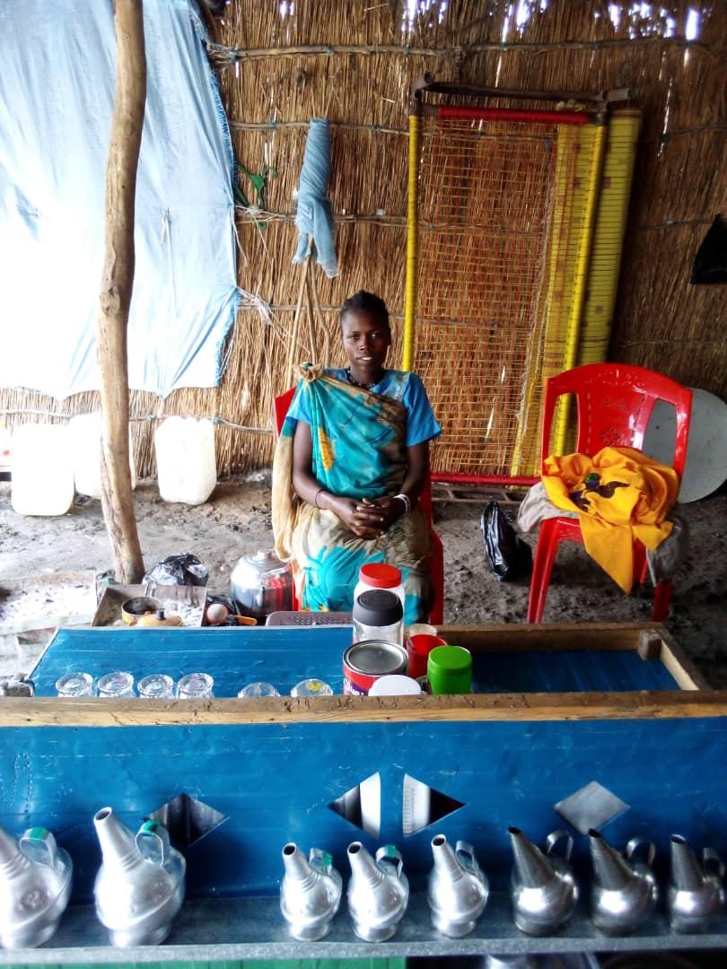 Mary sitting in her tea shop in Aburoc- Photo courtesy, WOCO Aburoc